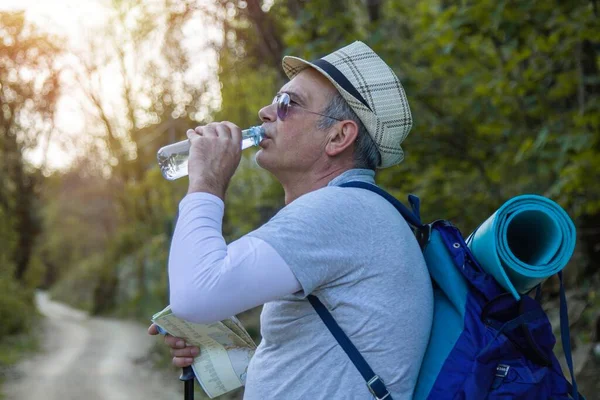 Yorgun dağcı bir içki molası verdi.