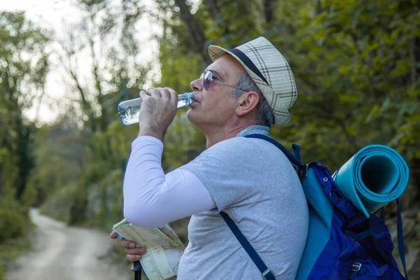 Yorgun dağcı bir içki molası verdi.