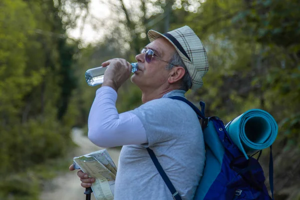 Yorgun dağcı bir içki molası verdi.