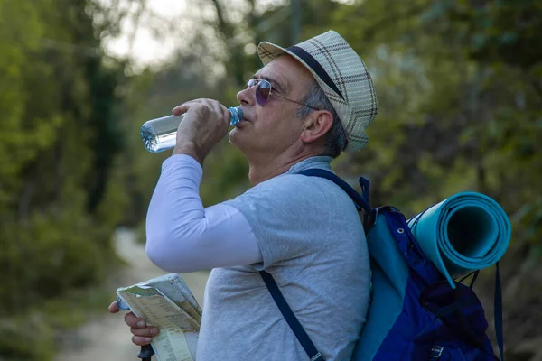 Yorgun dağcı bir içki molası verdi.