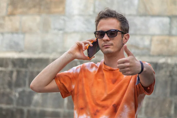 Молодий Чоловік Своїм Мобільним Телефоном Робить Знак Через Монументальні Вулиці — стокове фото