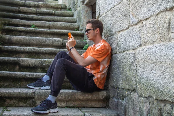 Mladý Muž Pomocí Mobilního Telefonu Sedí Schodech — Stock fotografie