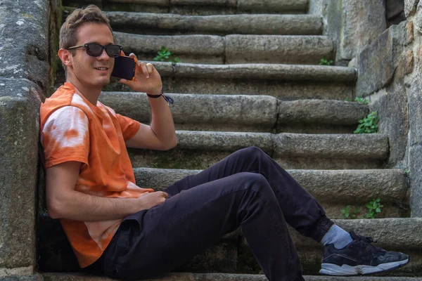 Νεαρός Άνδρας Που Χρησιμοποιεί Κινητό Τηλέφωνο Κάθεται Στις Σκάλες — Φωτογραφία Αρχείου