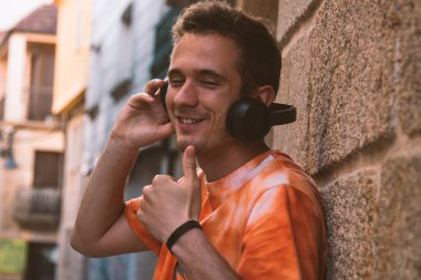 Kulaklıklı genç adam müzik dinliyor.