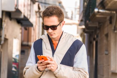 Kentin sokaklarında cep telefonu kullanan genç adam