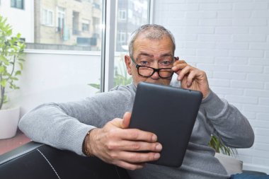 Prebyopialı ya da miyoplu bir adam dijital tablete bakarken şaşırdı.