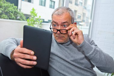 Prebyopialı ya da miyoplu bir adam dijital tablete bakarken şaşırdı.