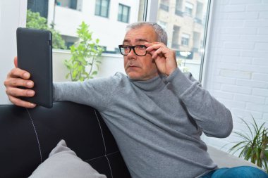 Prebyopialı ya da miyoplu bir adam dijital tablete bakarken şaşırdı.