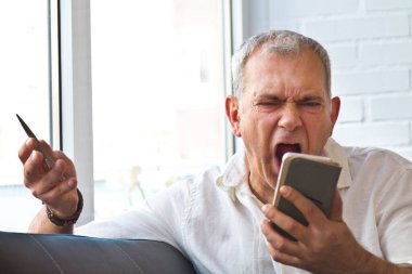 mature man yelling at mobile phone
