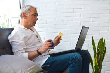 man with card and laptop at home or workplace
