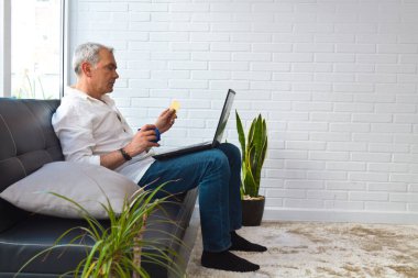 man with card and laptop at home or workplace
