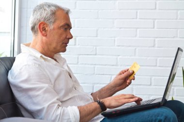 man with card and laptop at home or workplace
