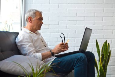 Bilgisayarı ve kredi kartı olan orta yaşlı bir adam.