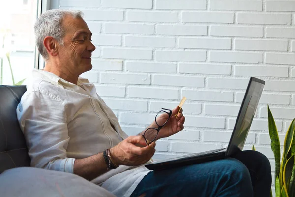 Bilgisayarı ve kredi kartı olan orta yaşlı bir adam.