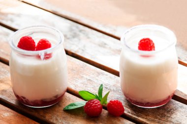 Greek yogurt with raspberries in glass jars