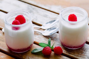 Greek yogurt with raspberries in glass jars