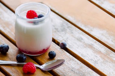 Greek yogurt with raspberries in glass jars