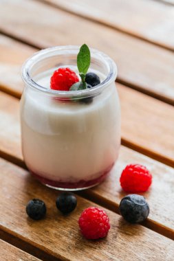 Böğürtlenli yoğurt ve cam kavanozlarda yabanmersini.