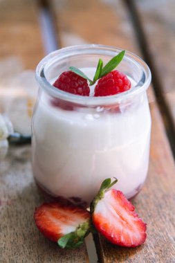 Ahşap arka planda çilekli yoğurt.