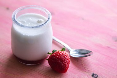 pembe bir arka plan üzerinde çilek ile yoğurt