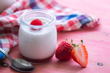 pembe bir arka plan üzerinde çilek ile yoğurt