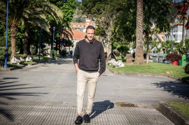 Yürüyüşte parkta yürüyen genç bir adamın portresi.