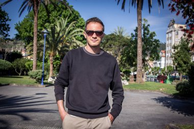 Yürüyüşte güneş gözlüklü genç bir adamın portresi.