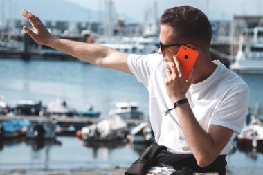 Cep telefonlu turist, limanın önünde el sallıyor, gezgin.