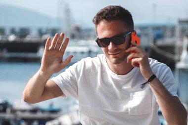 Cep telefonlu turist, limanın önünde el sallıyor, gezgin.