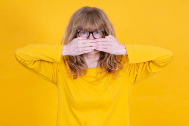 Kadın ellerini inkar ederek ağzını kapatıyor.