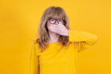 Kadın ellerini inkar ederek ağzını kapatıyor.