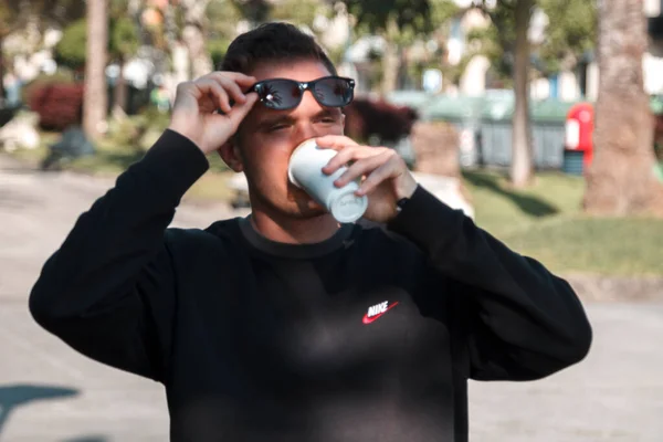Młodzieniec Pijący Kawę Spacerujący Parku Miejskim — Zdjęcie stockowe