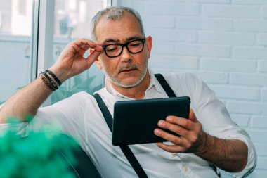 Evde ya da ofiste dijital tablet kullanan sıradan bir adam