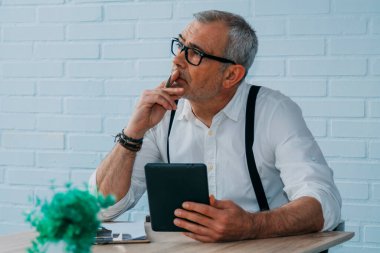 Evinde ya da ofisinde tableti olan hippi bir adam.