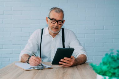 Evinde ya da ofisinde tableti olan hippi bir adam.