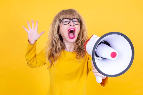 Sarı Arka Planda Megafonla Bağıran Olgun Bir Kadın — Stok fotoğraf