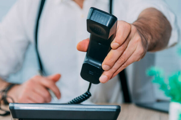 businessman using landline phone working at home or office