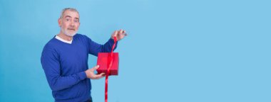 Aşık bir adam sevgililer gününde hediye kutusunu tutuyor.