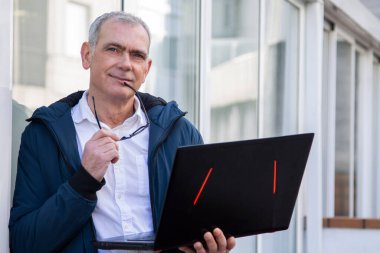 Gözlüklü ve bilgisayarlı olgun bir adam.