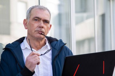 Sokakta dizüstü bilgisayar kullanan adam.