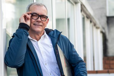 Gözlüklü ve bilgisayarlı olgun bir adam.