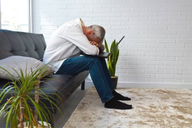 Ofisinde ya da iş yerinde dizüstü bilgisayarı olan sinirli bir adam.