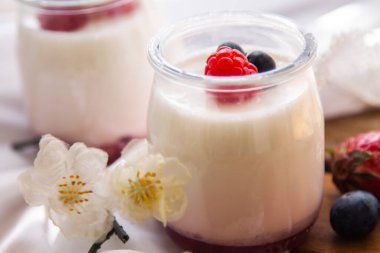 Ahşap arka planda yabanmersinli yoğurt.