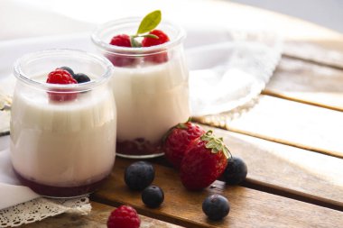 Ahşap arka planda yabanmersinli yoğurt.