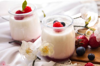 Ahşap arka planda yabanmersinli yoğurt.