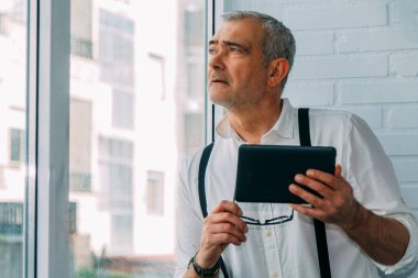 Ofiste veya işyerinde dijital tablet kullanan modern hipster adam