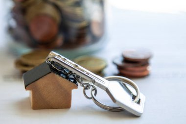 Belge, ipotek veya gayrimenkul kavramının üzerine ev anahtarlığı ve madeni paralar