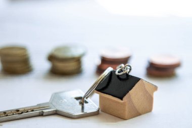 Belge, ipotek veya gayrimenkul kavramının üzerine ev anahtarlığı ve madeni paralar