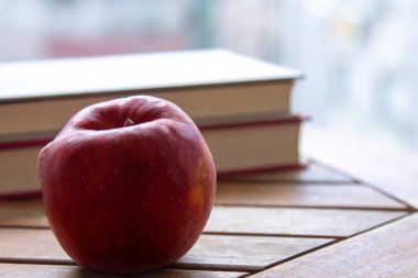 Okul konseptine dönelim. Masada elma olan bir kitap.