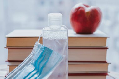 Kitap, elma ve tıbbi maske. Okul konseptine geri dönelim.